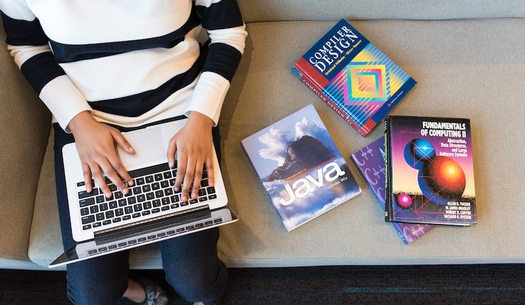 person in white and black striped top using MacBook