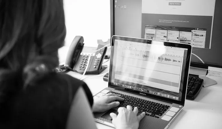 grayscale photo of person using laptop computer