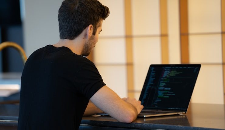 man in black t-shirt using laptop computer